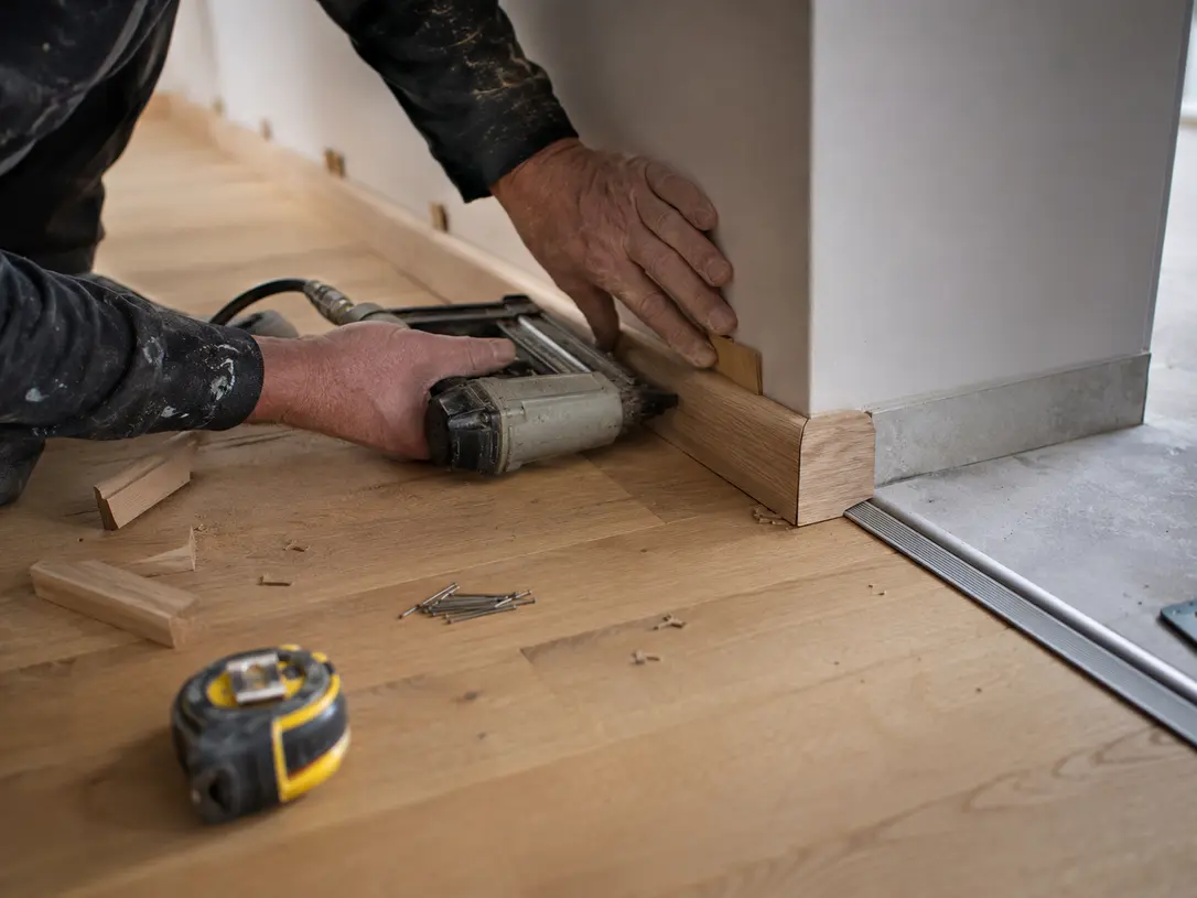 Finitions d’un parquet avec plinthes et seuils de porte